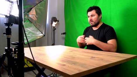 vlogger man recording youtube video in home green screen studio with camera
