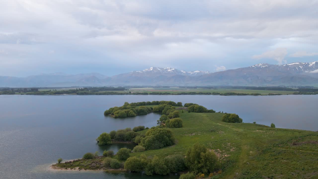 пышный зеленый мыс на альпийском озере после захода солнца
