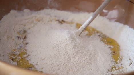 close up shot of person adding flour to biscuit dough into bowl