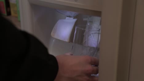 filling a glass of water from the fridge