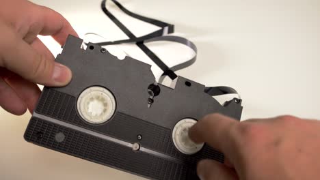 Manual-rewinding-of-VHS-tape-onto-the-reel-in-the-cassette