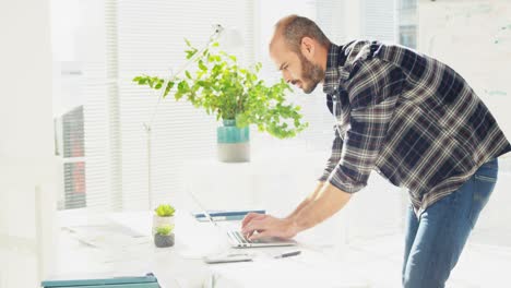 Male-executive-working-on-laptop-at-desk