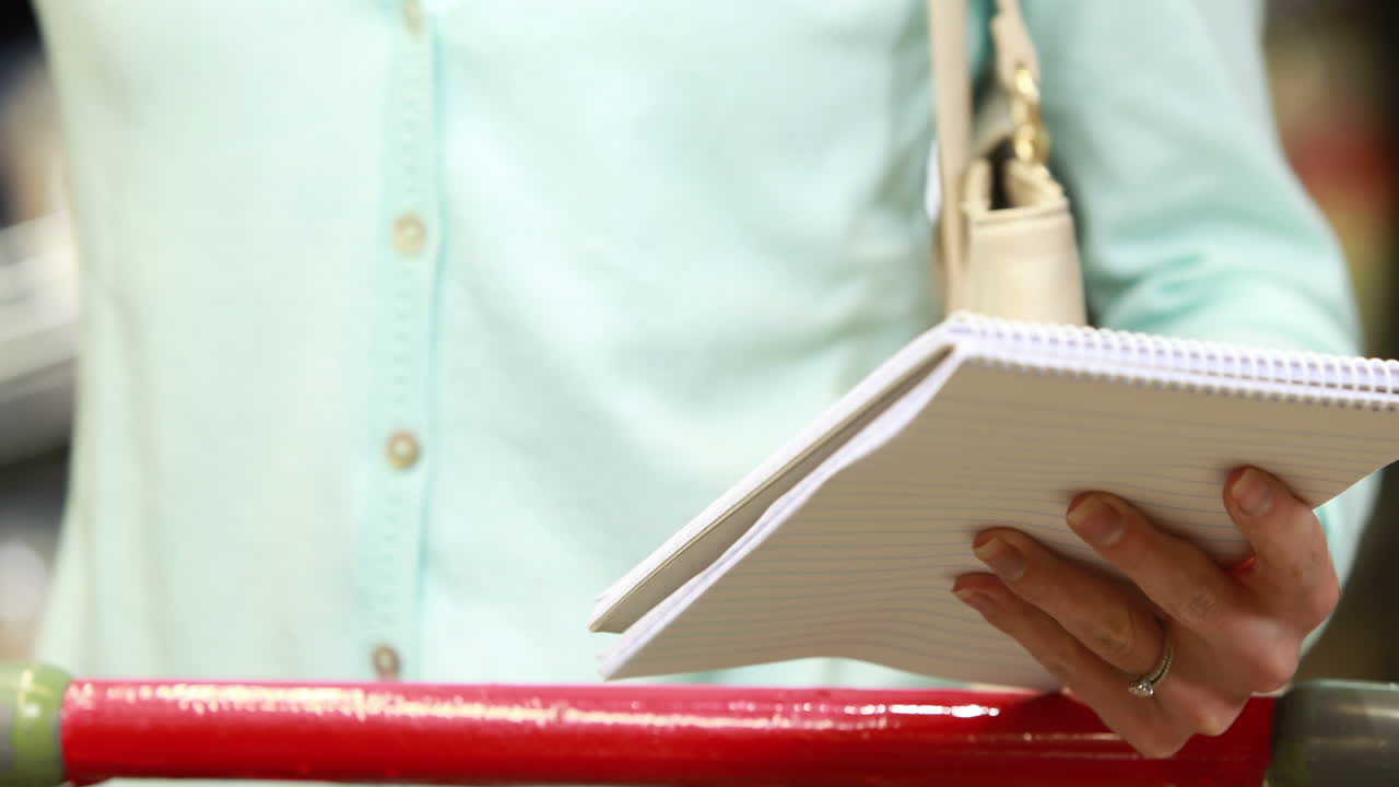 mujer marcando la lista de compras