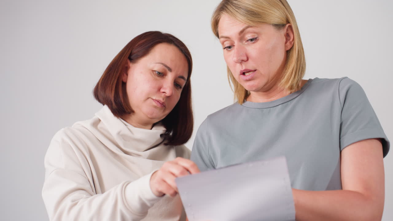 Stylists examining different textile samples together, focusing on selecting best material for design, collaborating closely while carefully analyzing options for creative project