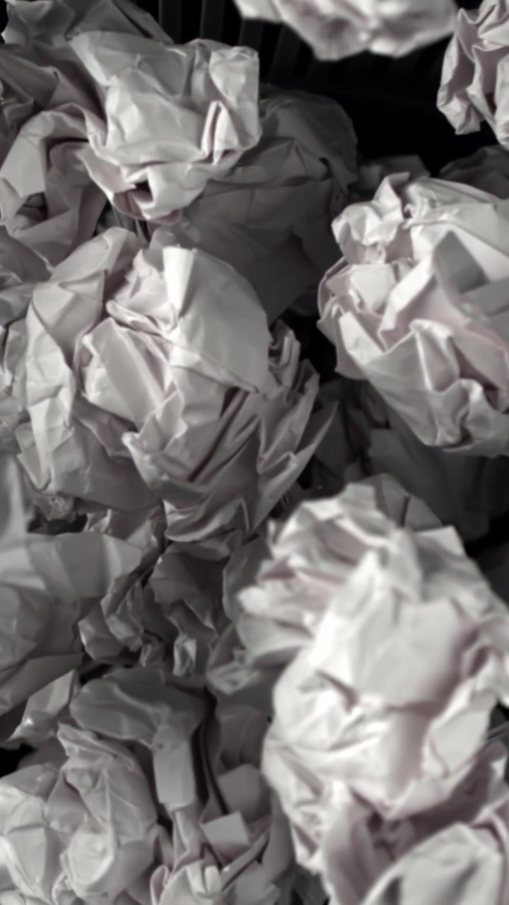 Crumpled Paper Balls Falling into a Trash Can