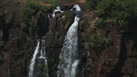 amazing dramatic stream falling down steep rocky cliff in beautiful jungle enviornment, waterfalls seeping through rough terrain in holiday destination in iguazu falls, brazil, south america