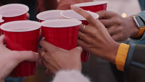 close up friends making toast drinking enjoying rooftop party having fun celebrating friendship gathering at sunset