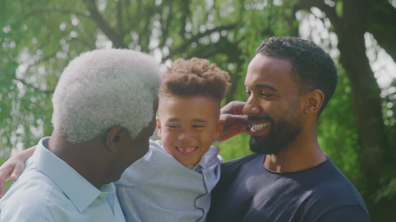 sonriente familia masculina de varias generaciones en casa en el jardín juntos
