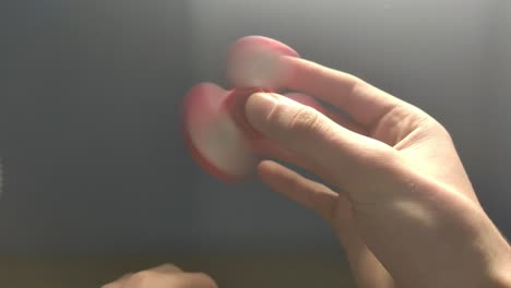 white man spinning a fidget spinner on a table