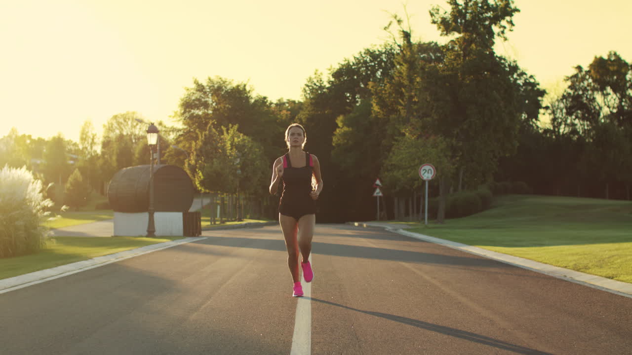 mujer deportiva corriendo en el parque al atardecer. mujer corredora entrenando corriendo al aire libre