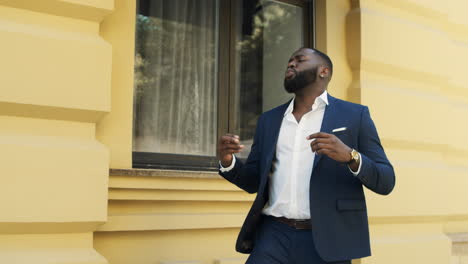 Afro-businessman-dancing-on-city-street.-Happy-man-receiving-good-news.