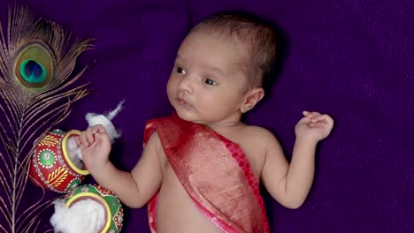 newborn baby boy in krishna dressed with props from unique perspective in different expression