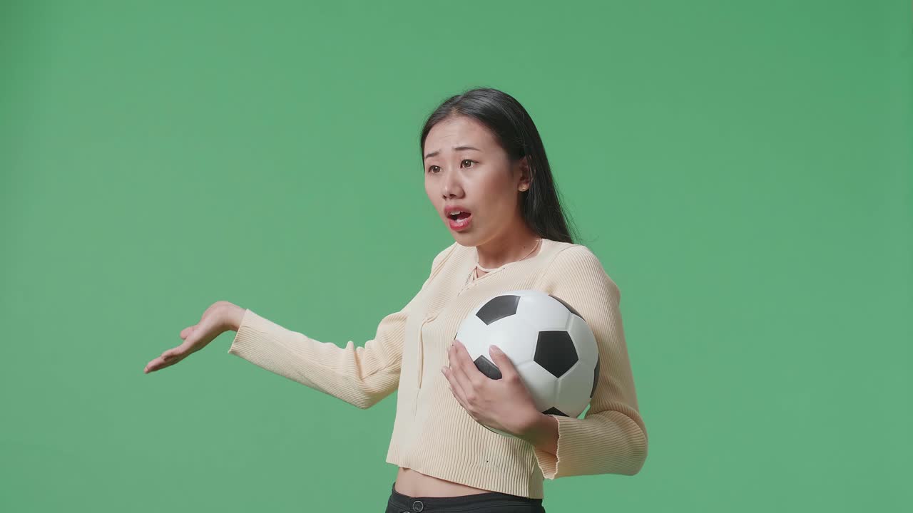 혼란 스럽게 보이는 축구 공을 들고 있는 여자