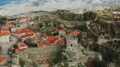 historical-Iberian-walled-town-and-castle-remnants-on-rugged-hilltop,-Sortelha,-Portugal,-dolly-in-aerial