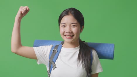 mujer feliz viajera con mochila y estera de yoga