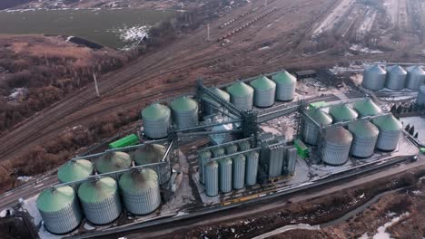 metal silos on field aerial view. large containers for storing and processing grains. silver grain elevators in farmland. storage tank view from above. silo with grain.