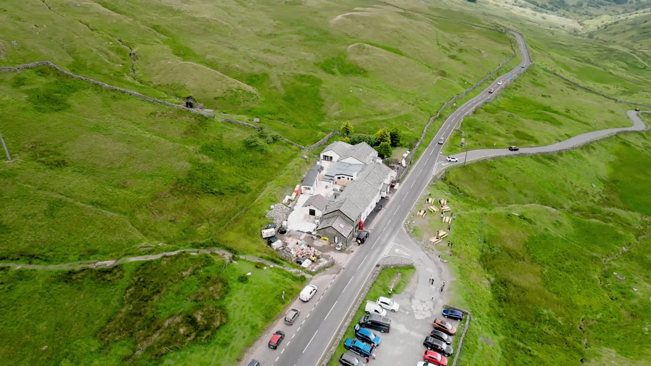 The Kirkstone Pass Inn From Above With Busy Road A592. Parking lot full. Summer. Kirkstone Pass, Lake District, Cumbria, UK