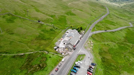 the kirkstone pass inn from above with busy road a592. parking lot full. summer. kirkstone pass, lake district, cumbria, uk