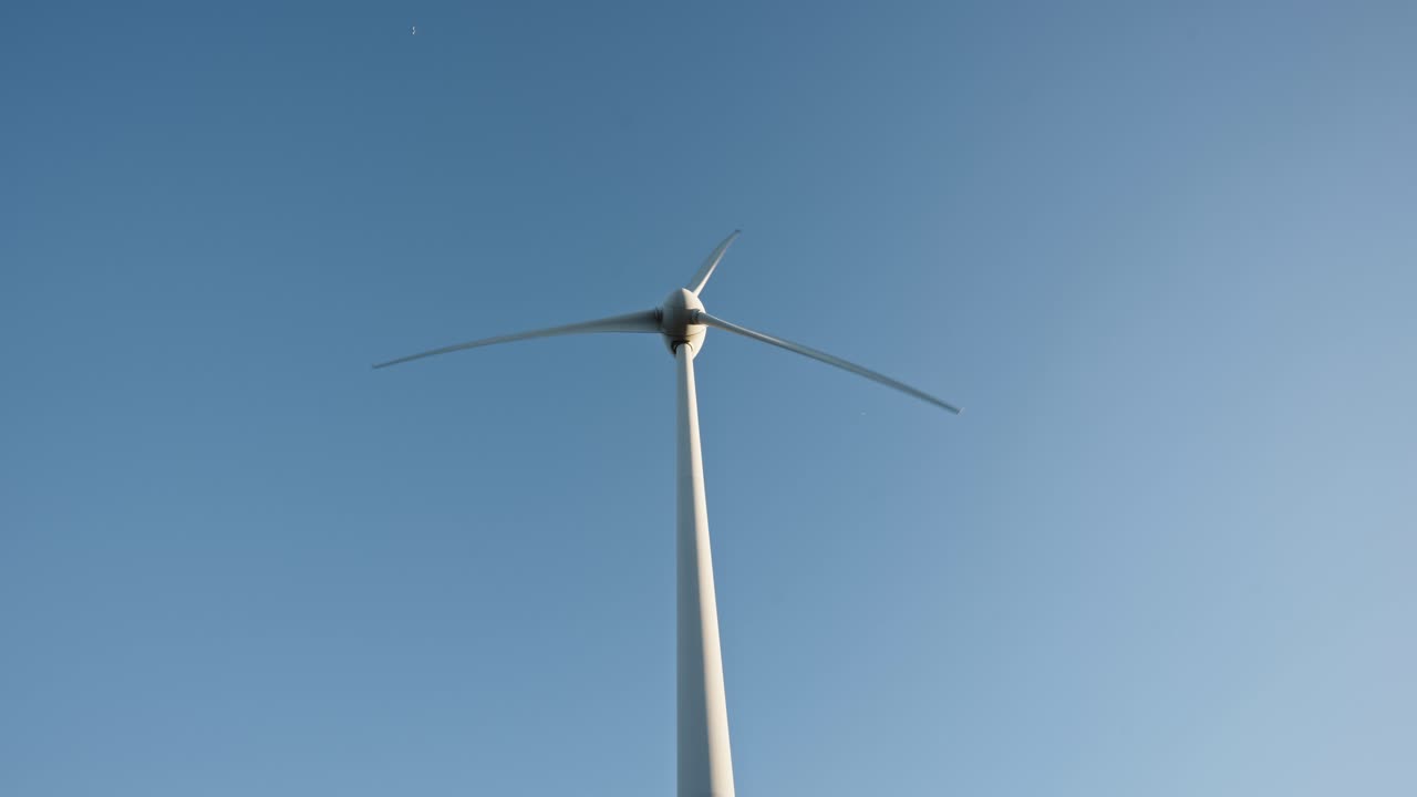 은 파란 하늘을 배경으로 풍력 터빈, 움직이는 블레이드, 풍력 에너지를 활용하는