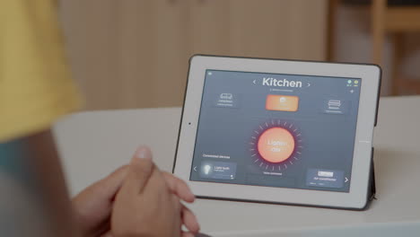 man talking to voice assistant on tablet in smart home automation system