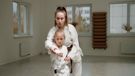 pupil and teacher in white kimono in martial arts class