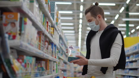 hombre con máscara de compras en la tienda de comestibles