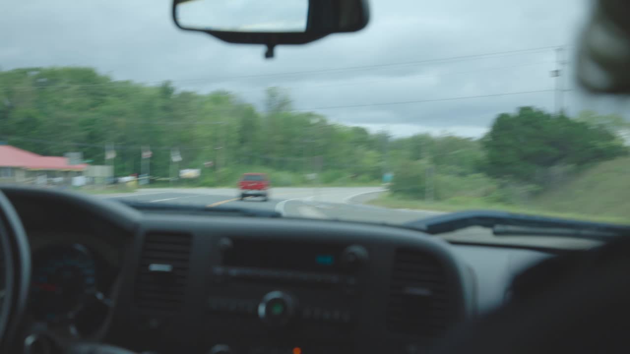 View Inside A Car Through The Windshield As It Turns Left On The Road - wide shot