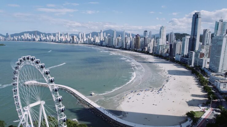 Aerial view of Balneário Camboriú beach and cityscape with a large Ferris wheel in Brazil