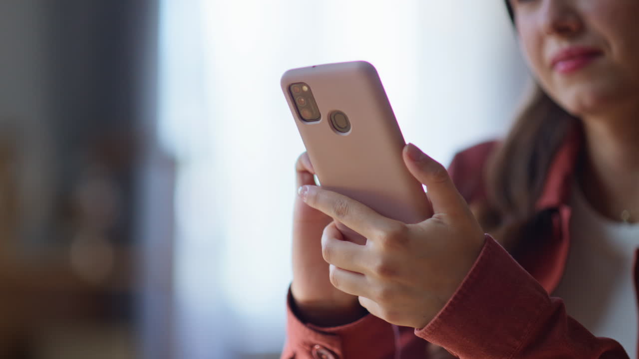 Student hands swiping smartphone in apartment closeup. Woman browsing internet