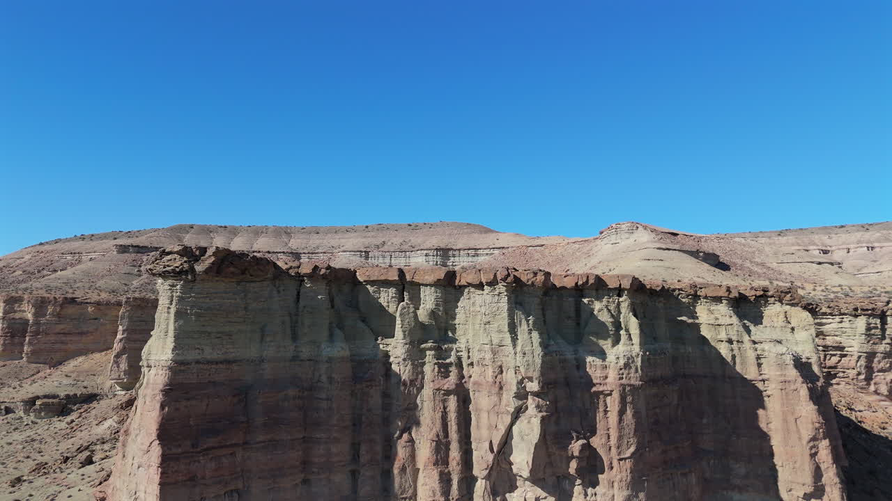 Experience a sweeping aerial dolly over the rugged desert cliffs of Chubut Province in Argentina, renowned for its dry inland climate, semi-arid coast, and iconic Patagonian views.