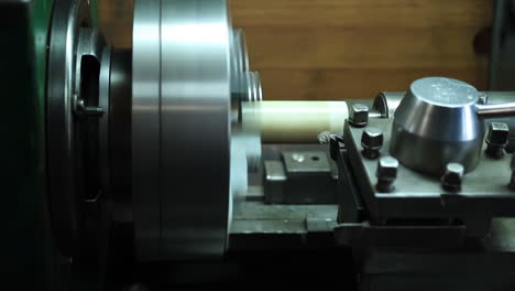 lathe technician engineer worker service skilled machinist working intently on a large industry in metal factory workshop with large machines