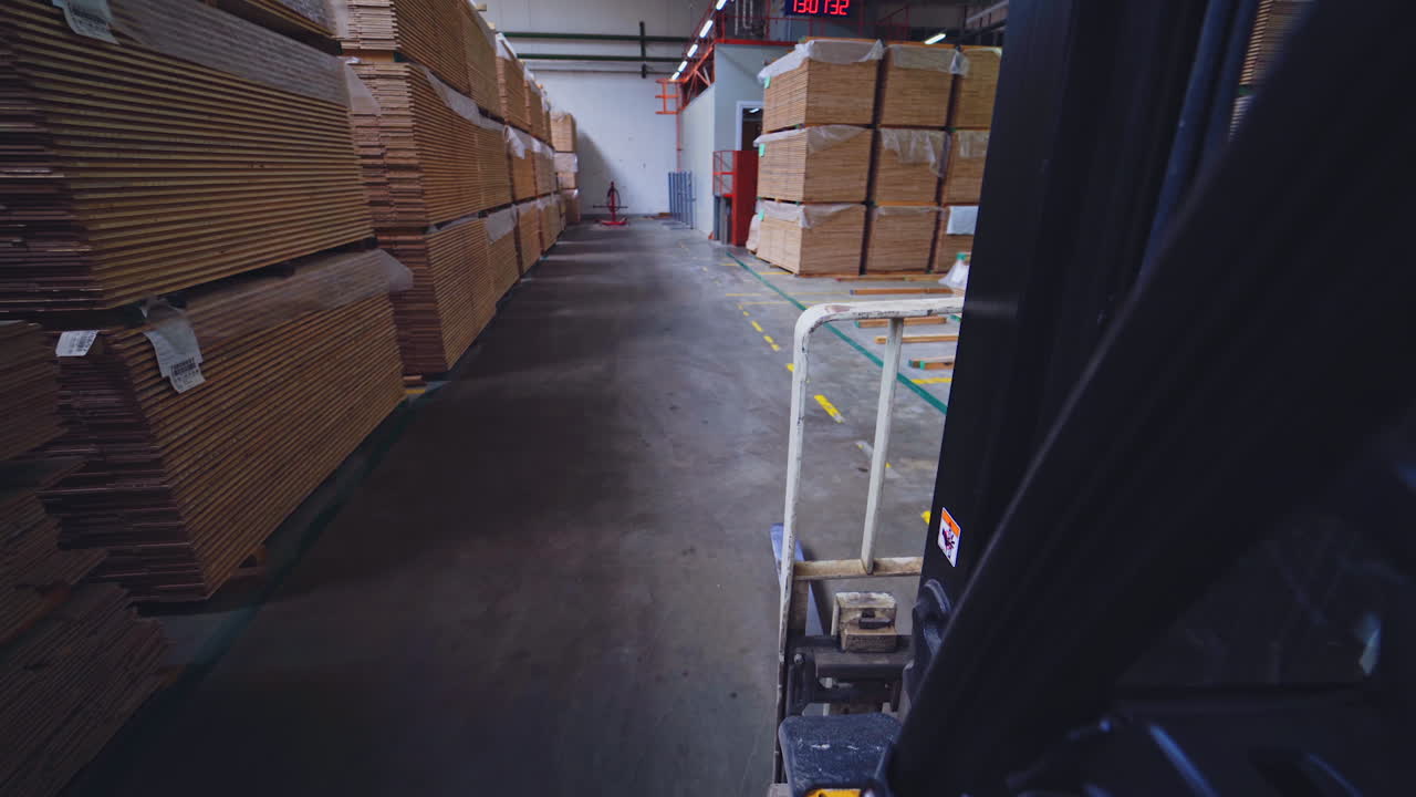 Production of wooden parquet. Piles of parquet boards inside the factory of furniture industry. View from forklift cart.