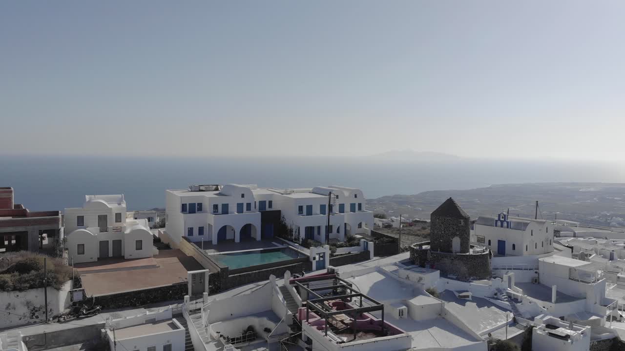 en lo alto de santorini, moscas aéreas hacia villa de molino de viento de piedra redonda