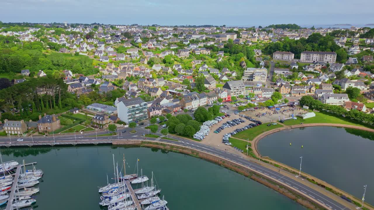 Forward drone movement over the marina with docked yachts along the coastal settlement of Perros-Guirec, Brittany, France.