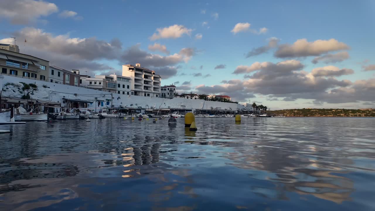 Timelapse of Es Castells seafaring village in Menorca Island in Spain. Afternoon warm light reflected on the Sea. 4K