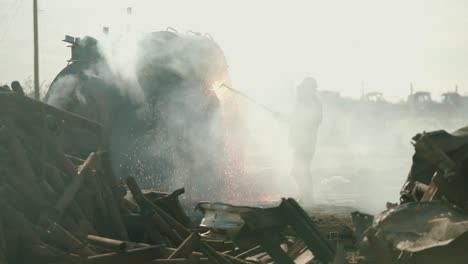 metal torcher cutting metal at a scrap yard in slow motion with fire and sparks