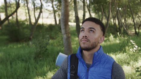 Portrait-of-happy-african-american-man-hiking-in-forest,-copy-space,-slow-motion