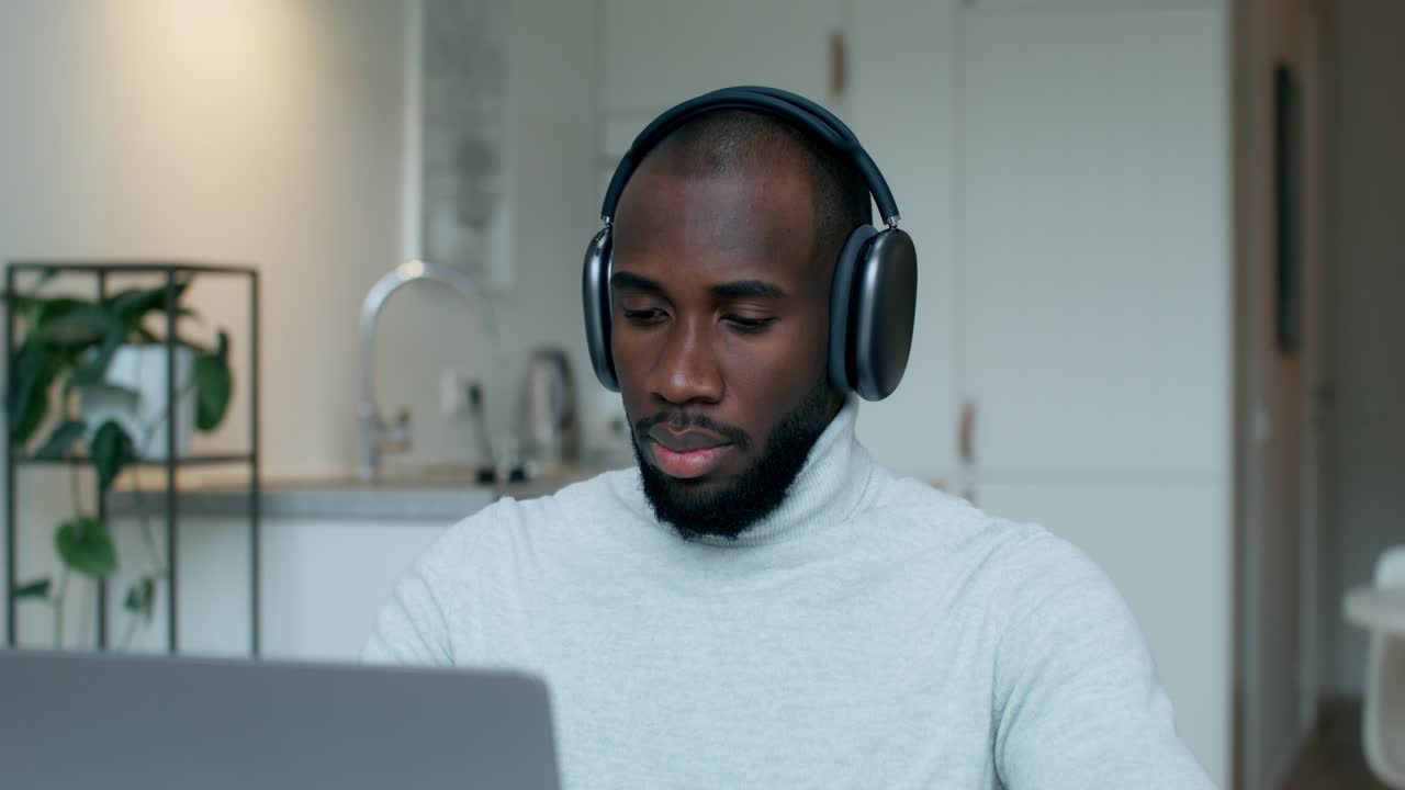 Man working on laptop with headphones
