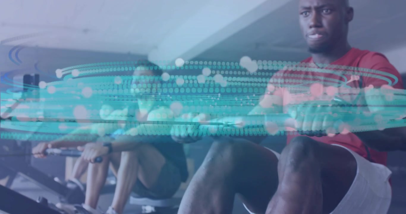 Rowers starting rowing on machines in unison in gym showing data overlay tracking workout metrics