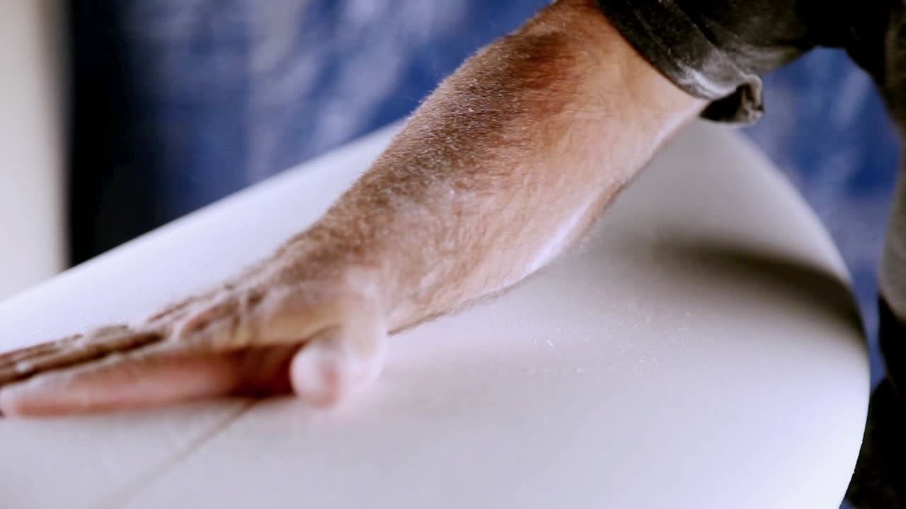 한 남자가 서핑보드를 만들고 있다