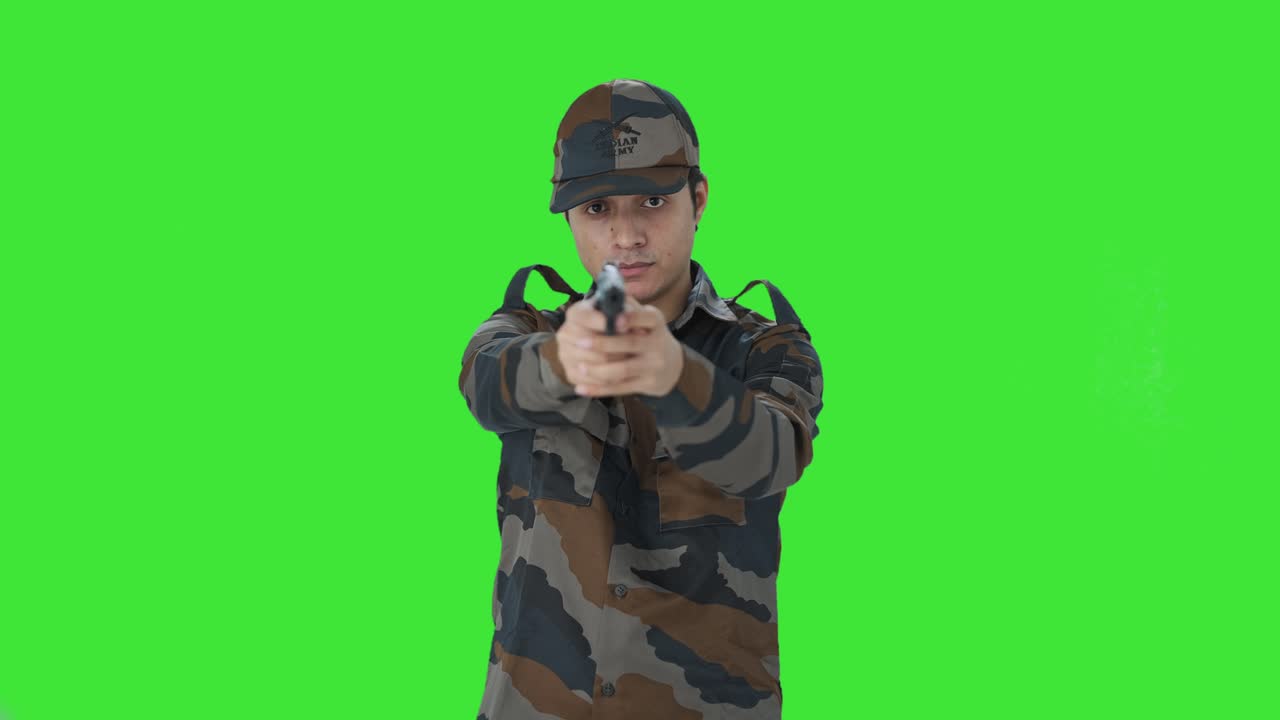 인도 군대 남자 는 손 총 을 겨냥 하여 녹색 스크린 을 찍는다