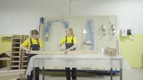 carpinteros que ensamblan piezas de muebles en una fábrica
