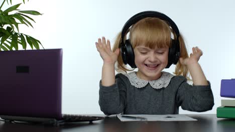 Child-schoolgirl-kid-laughing-and-smiling.-Learning-lessons-at-home-and-using-laptop-computer