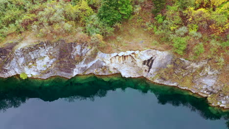 a top down view over a quarry filled with green water