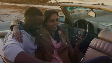 animation of happy diverse couple taking selfie in cabriolet