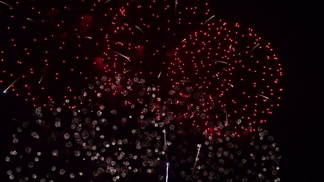 Smoke and brilliant colors fill the night sky as fireworks explode one ...
