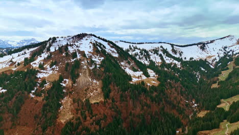 snow-capped mountains with some green and dry pine trees on the slopes. drone footage over the wilderness in germany, bavaria.