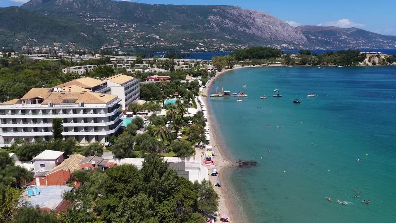 Vista aérea de drone da costa do resort de Dassia com edifícios de hotéis, piscina e mar turquesa em Corfu, Grécia.