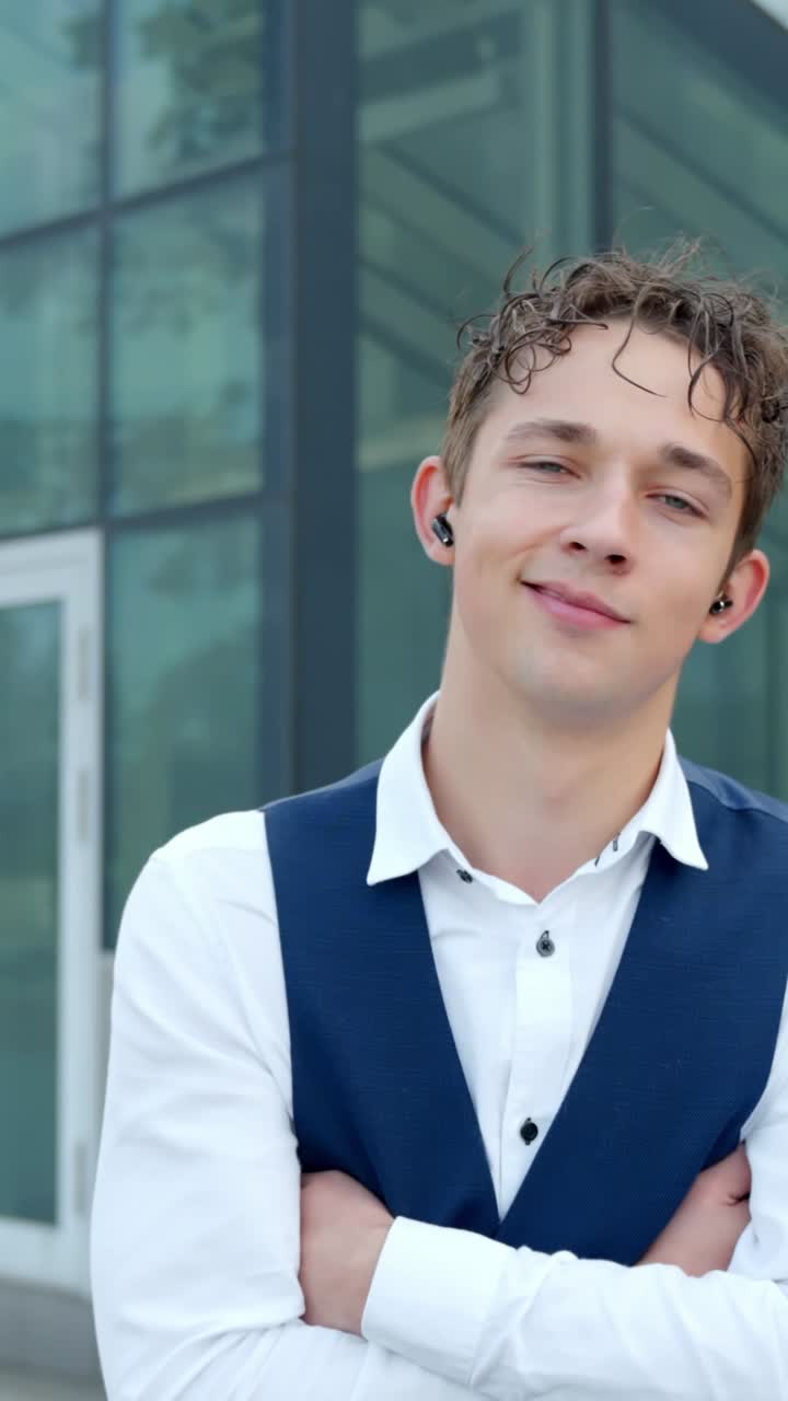 Close-up of smiling businessman with earbuds as camera slowly pulls back