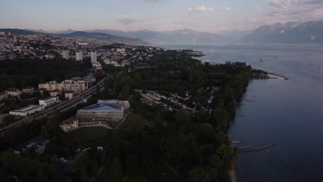 slow aerial high above lausanne, switzerland at sunset with lake geneva and the swiss alps in view